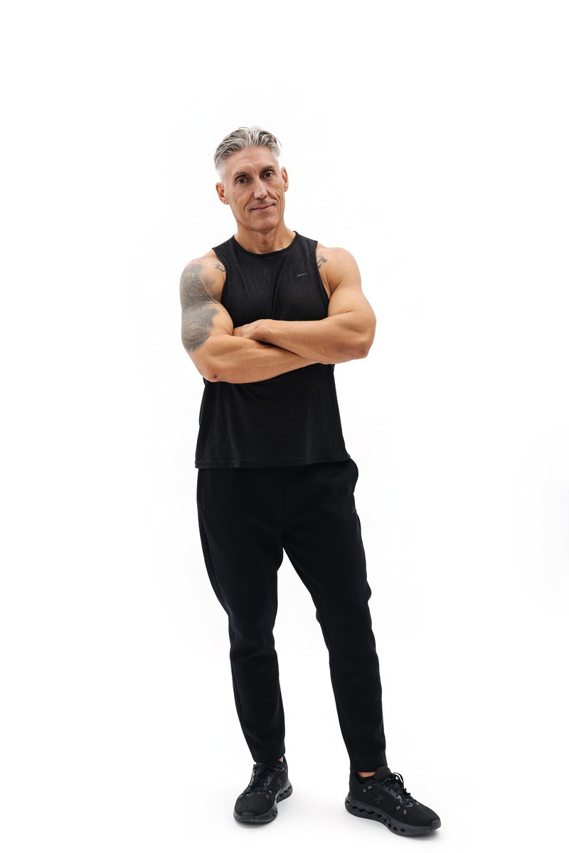 Juan Manuel de cuerpo entero en ropa de entrenamiento negra, postura firme y relajada